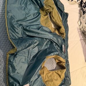 Stio Green Women's puff vest.  Interior is green and teal.  Zips and buttons.